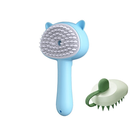 A light blue pet grooming brush with cat-ear details and white silicone bristles, shown alongside a smaller green-and-white alternative brush on a plain white background.