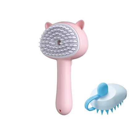 A pink pet grooming brush with cat-ear details on the handle and head, shown alongside a smaller blue and white alternative brush on a plain white background.