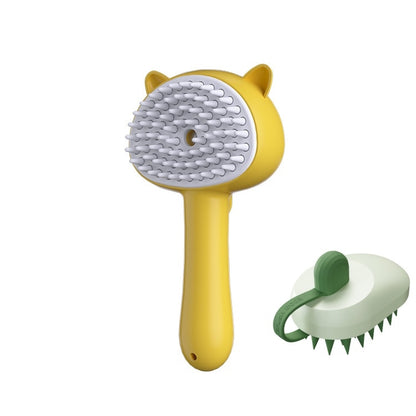 A yellow pet grooming brush with a white silicone bristle head and cat-ear details, shown alongside a smaller inset view of the brush from the back on a plain white background.