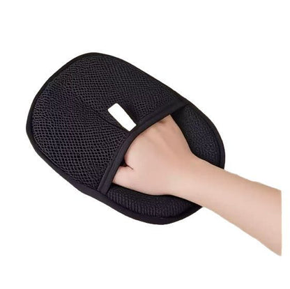 Black mesh bath glove being worn on a hand against a white background