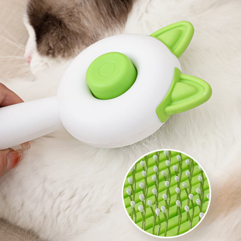 Cat grooming tool with green and white design, held by a person, on a soft surface.