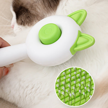 Cat grooming tool with green and white design, held by a person, on a soft surface.