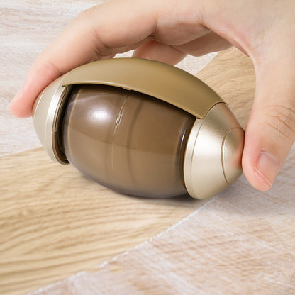 Hand holding a cylindrical brown and beige object on a wooden surface