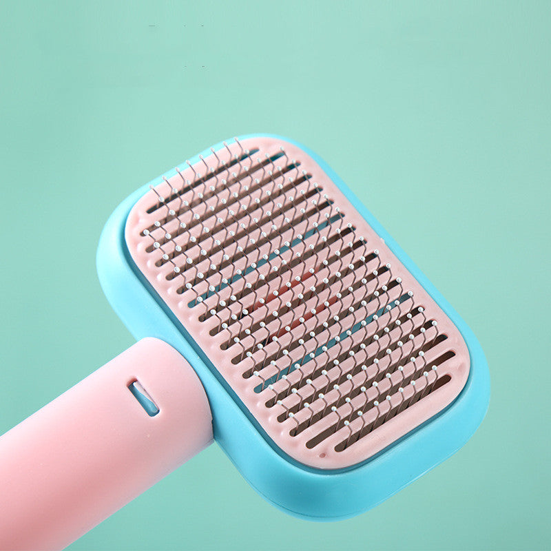 Pink and blue pet grooming brush on a light green background