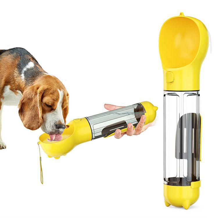 Yellow portable pet water bottle being used by a dog on a white background