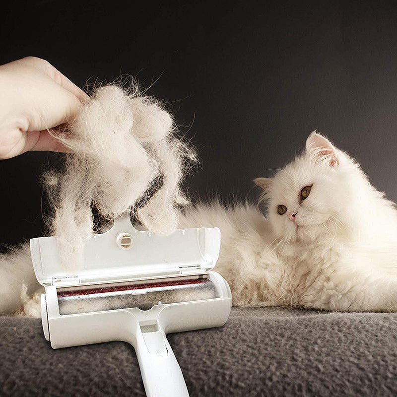 White cat sitting next to a pet grooming roller with collected fur on a dark background