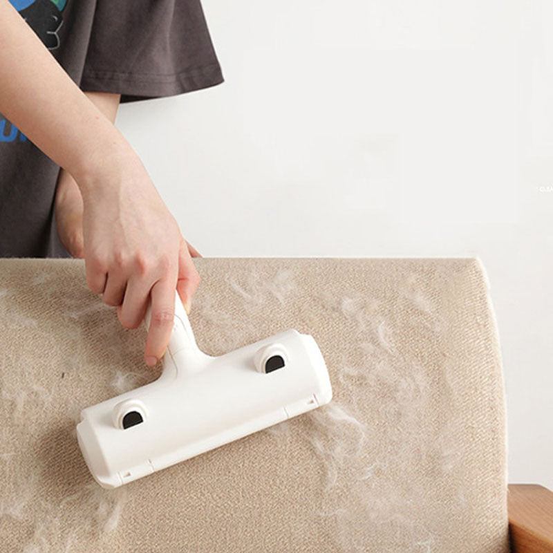 Person cleaning a beige carpet with a white cleaning tool.
