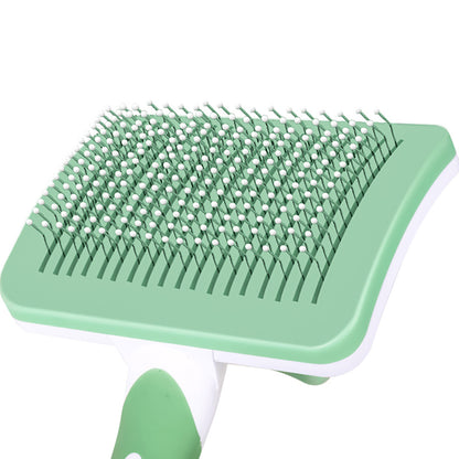 Green pet grooming brush on a white background